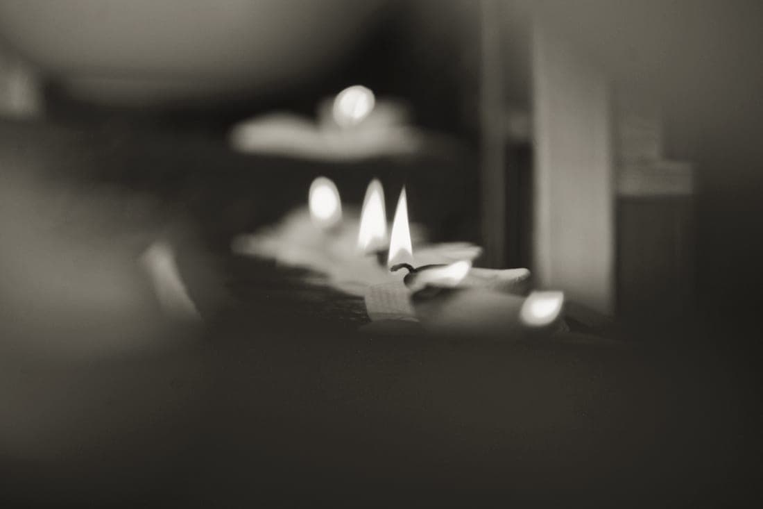 Candle flames and melted wax pools in close-up
