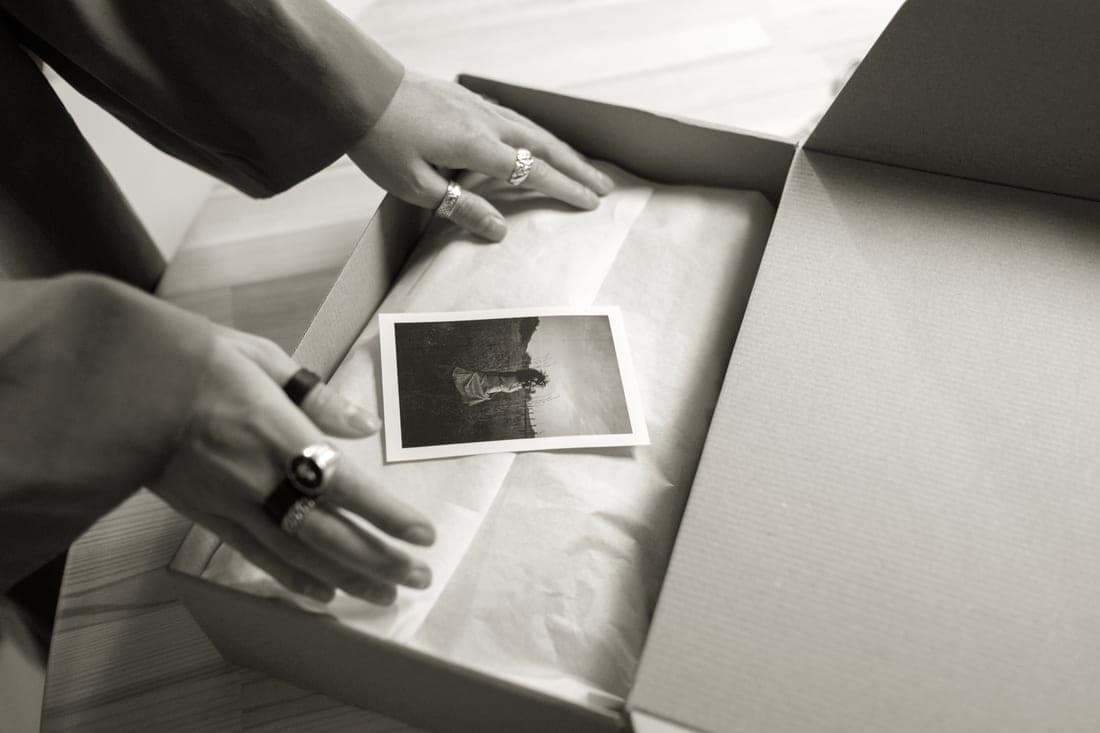 A gift box being assembled with tissue and small handmade items