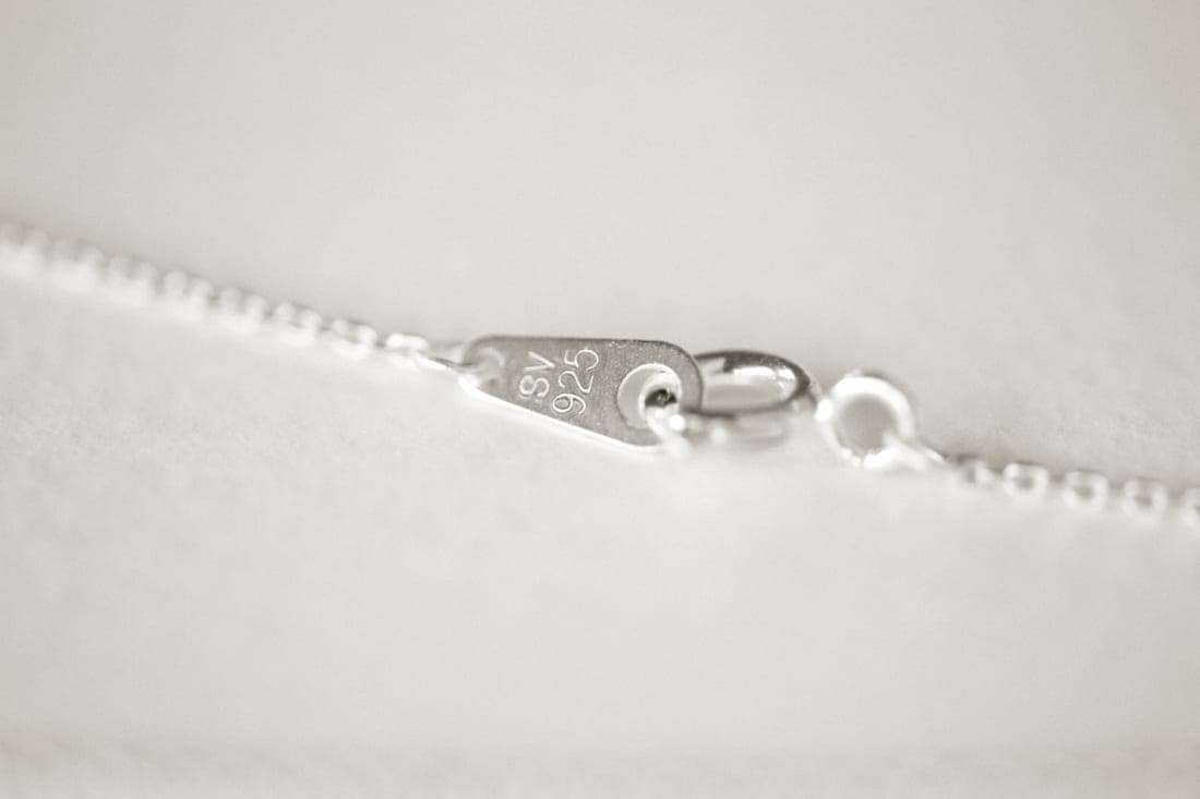 A sterling silver chain with a small tag stamped 925 beside the clasp