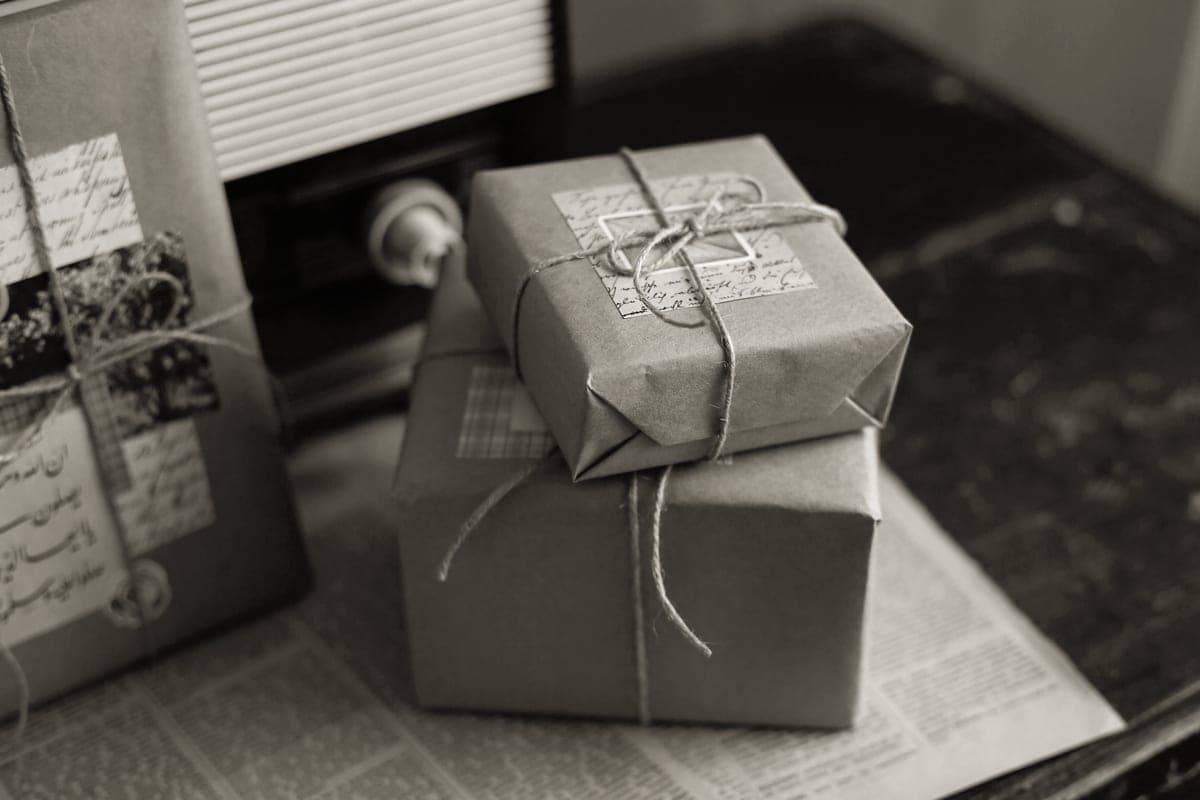 Gifts wrapped in brown paper and twine on a wooden surface