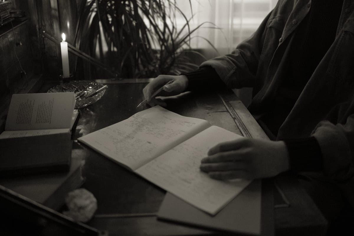 An open notebook and pen on a desk in warm light